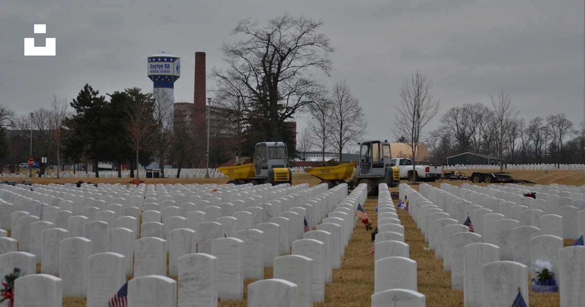 Foto zum Thema Ein Feld voller weißer Grabsteine mit einem Lastwagen im