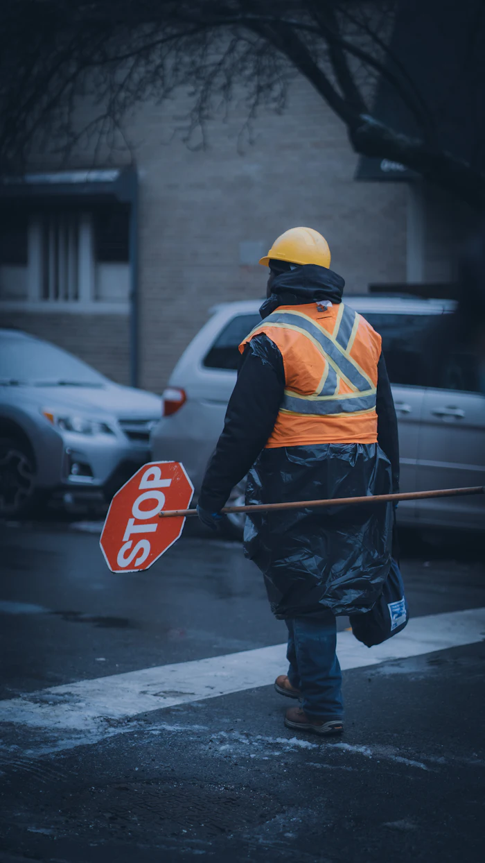 Traffic controller in hi-vis carrying a stop bat