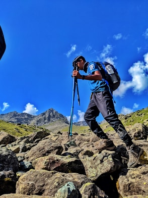 a man hiking up a rocky mountain with a backpack