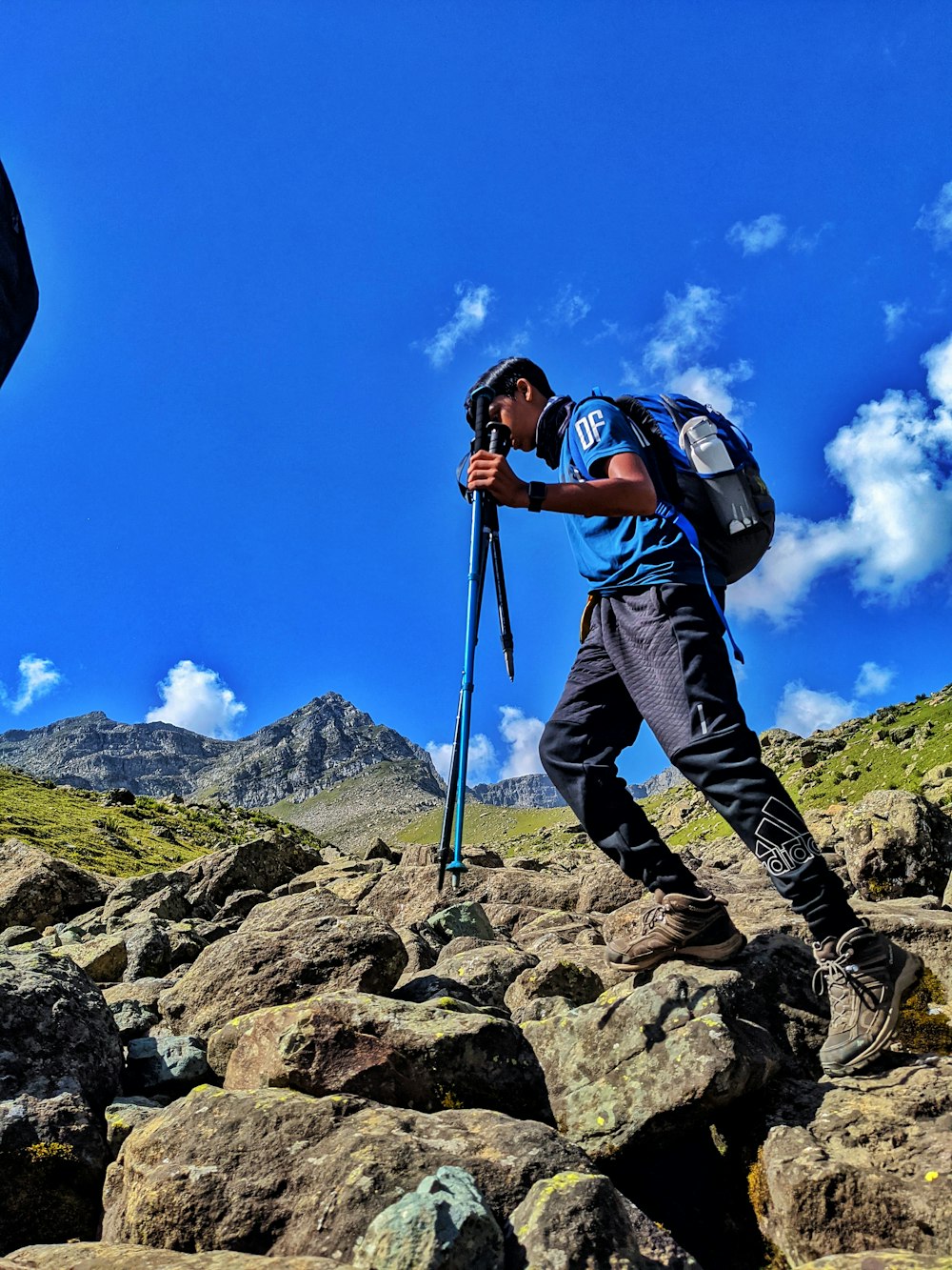 a man hiking up a rocky mountain with a backpack