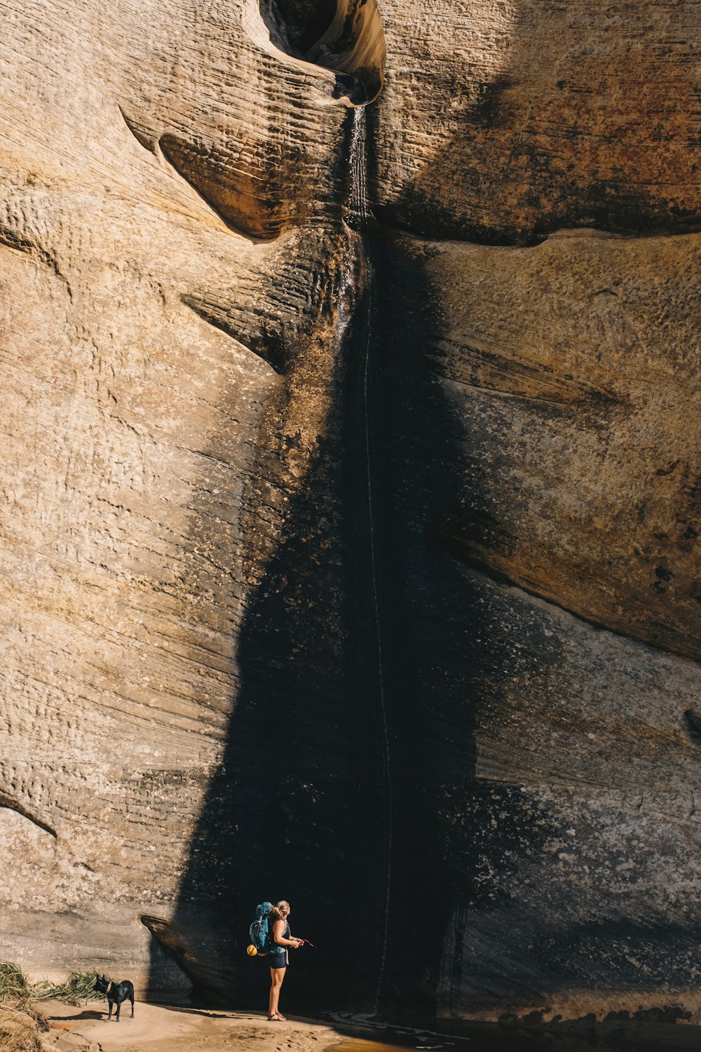 a person standing on a beach next to a cliff