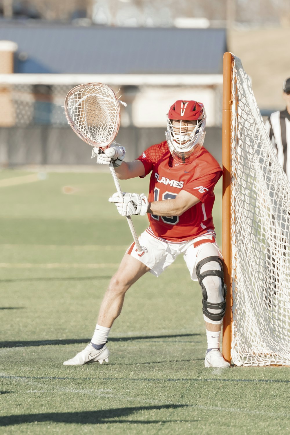 a man holding a lacrosse racquet on top of a field