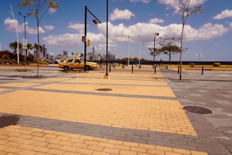 A modern taxi parked in front of a city skyline.