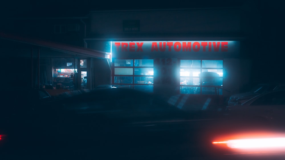 un coche aparcado frente a una tienda por la noche