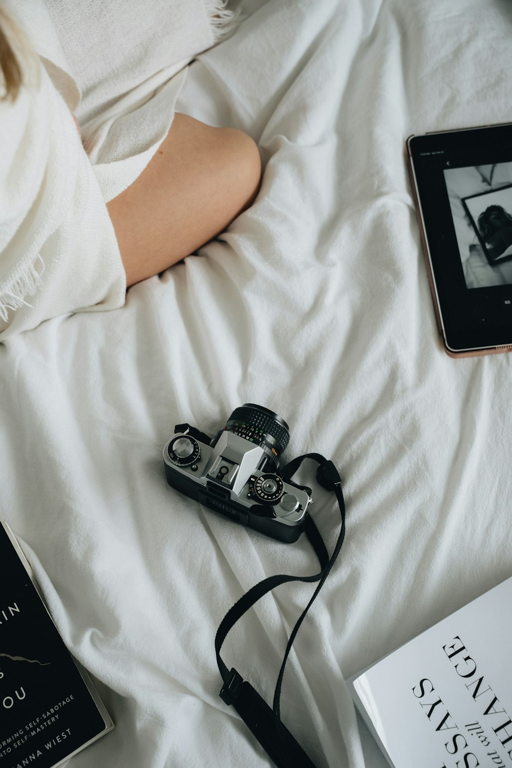a camera and a book on a bed