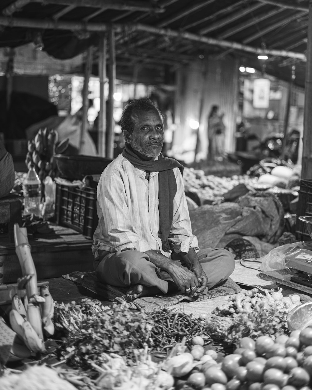 a man sitting on the ground in a market