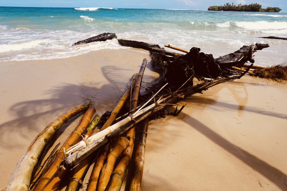 uma pilha de bambu sentado em cima de uma praia de areia