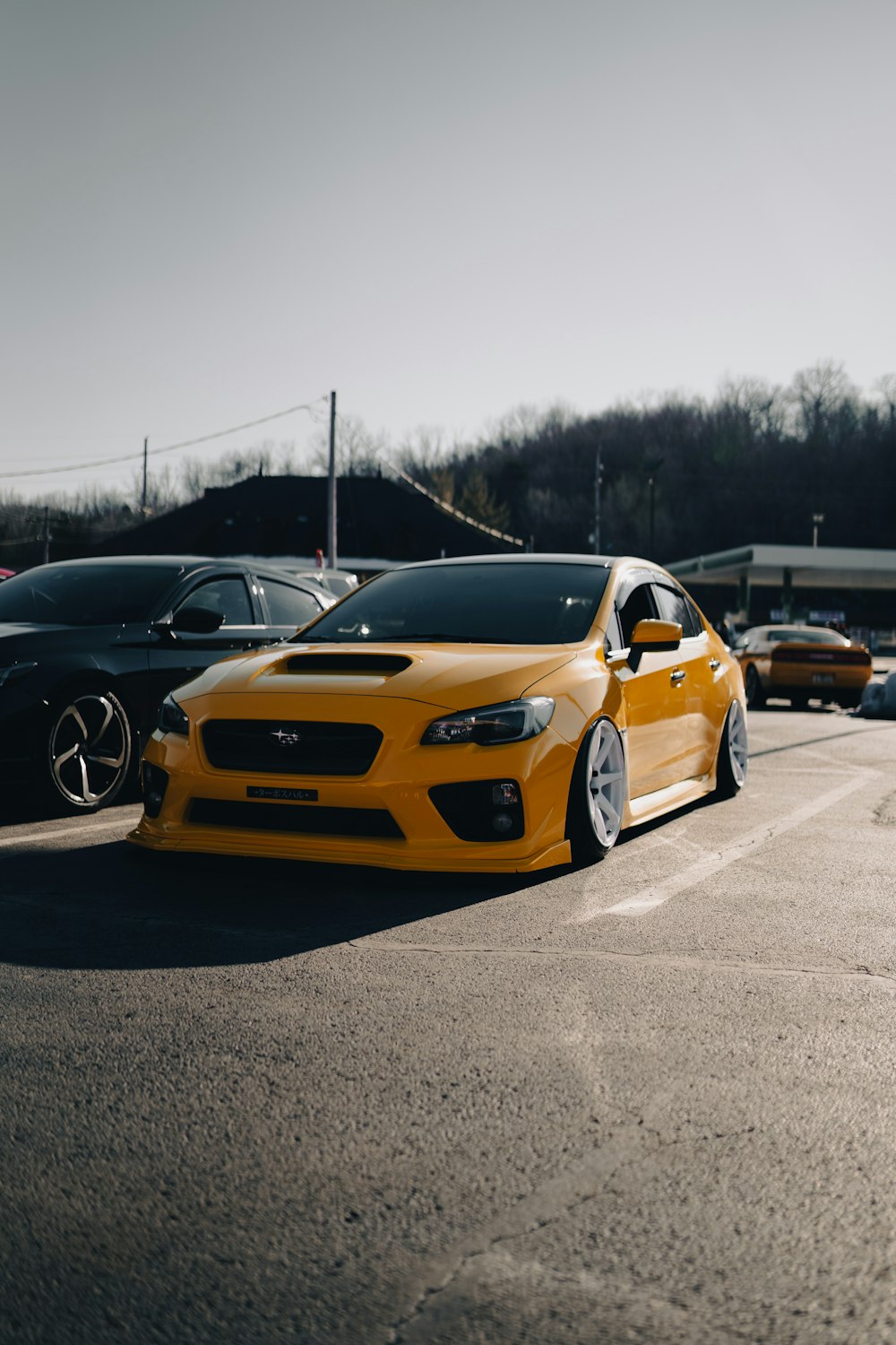 a yellow car is parked in a parking lot