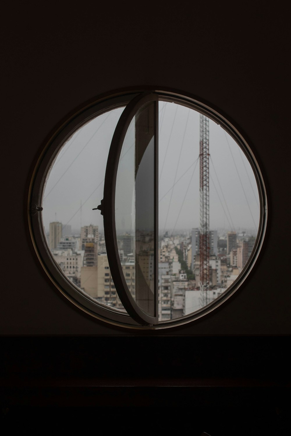 Blick durch ein rundes Fenster auf eine Stadt