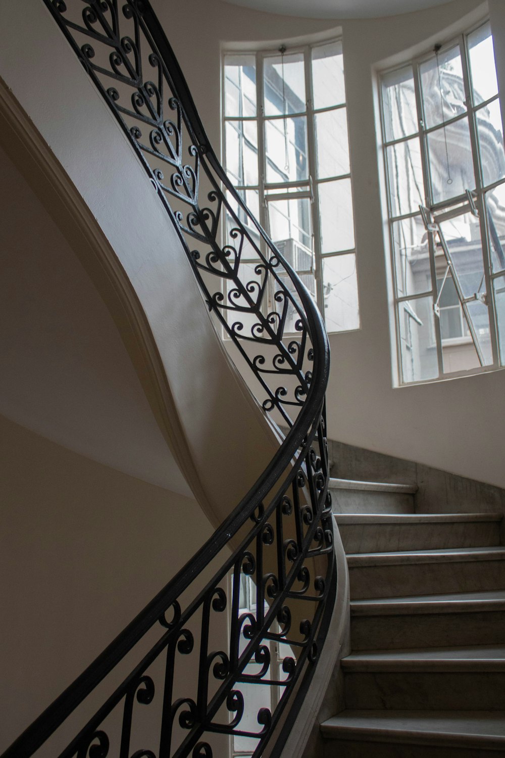 a spiral staircase in a building with two windows