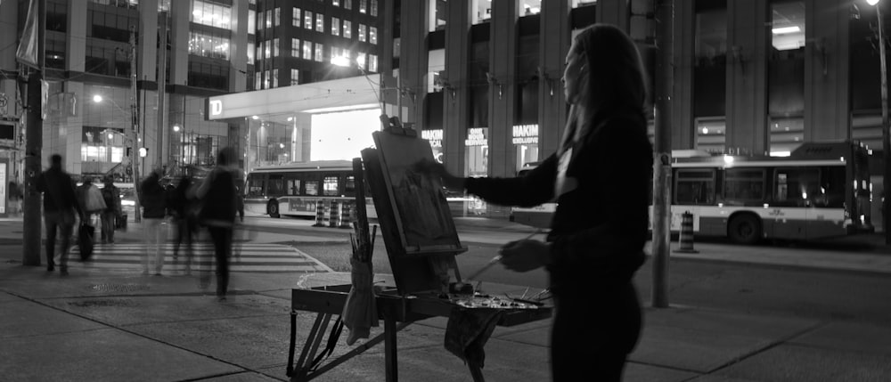 a black and white photo of a woman painting