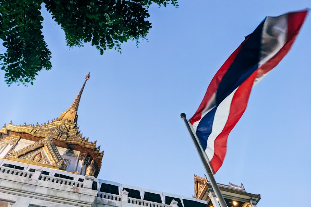 uma bandeira tailandesa voando na frente de um edifício