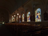 A peaceful church interior with stained glass windows glowing during a music session.