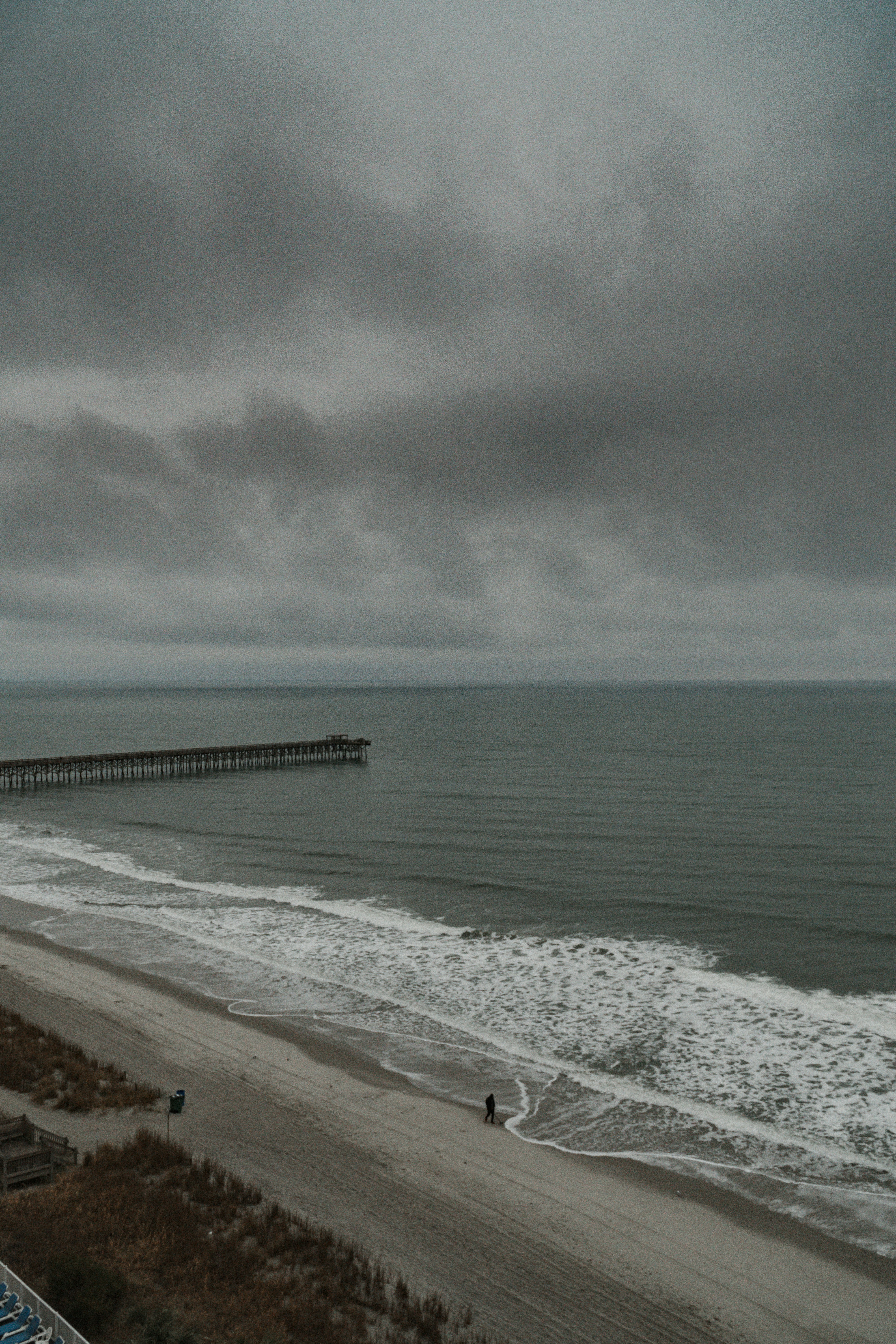 Una vista de una playa con un muelle en la distancia