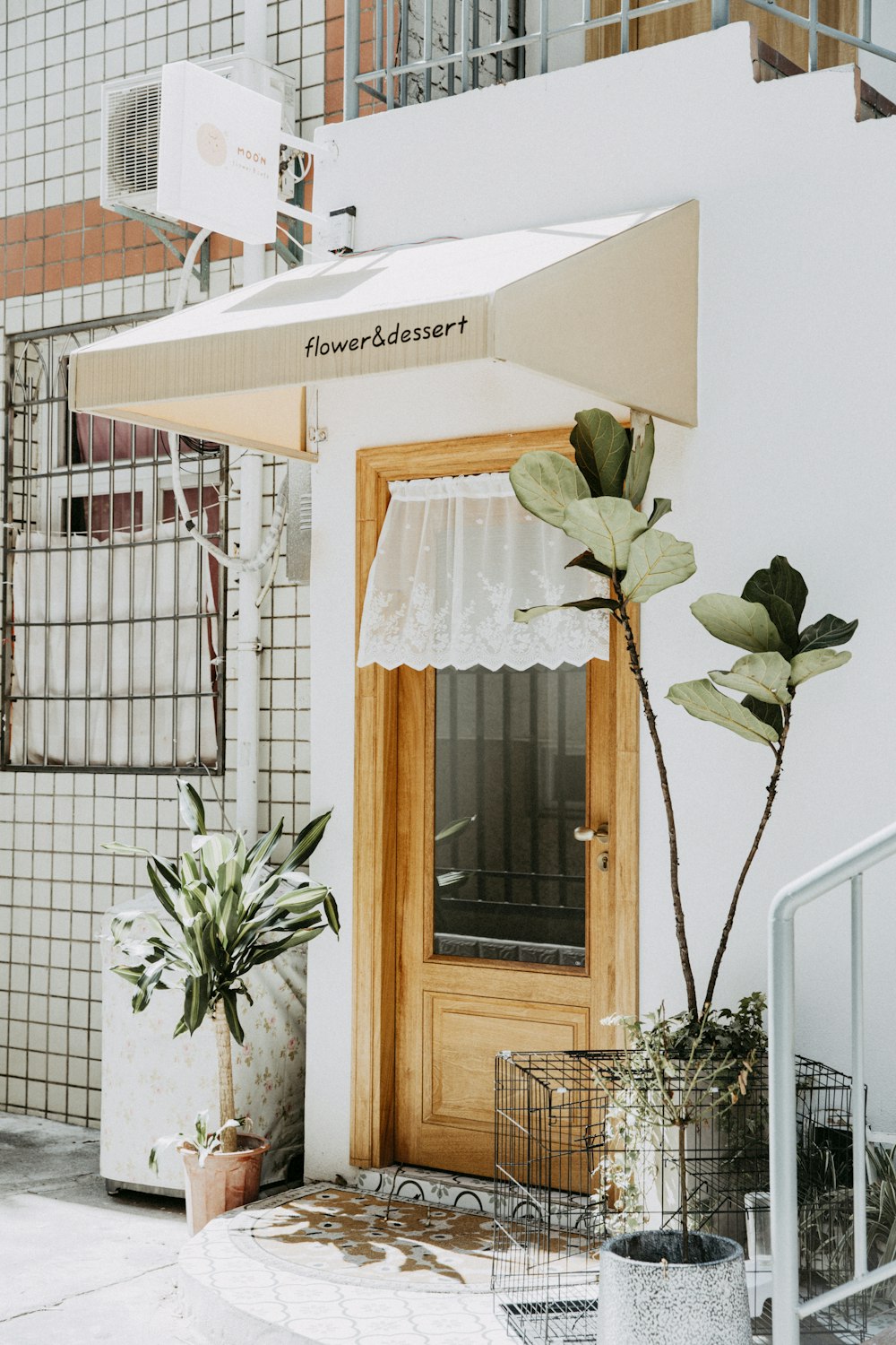 a white building with a wooden door and a white awning