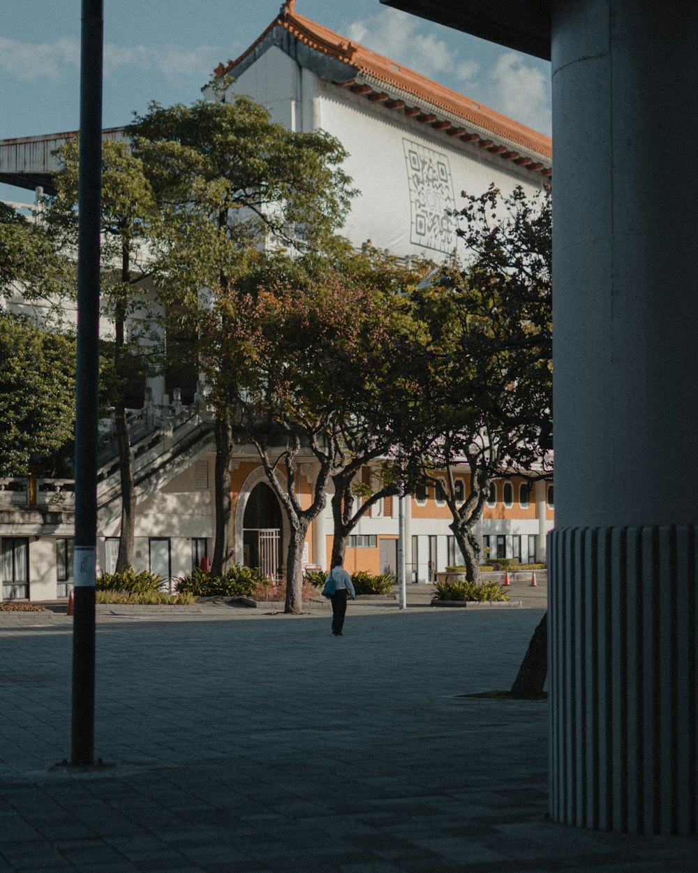 a person walking down a sidewalk in front of a building