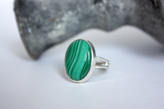 a green ring sitting on top of a rock