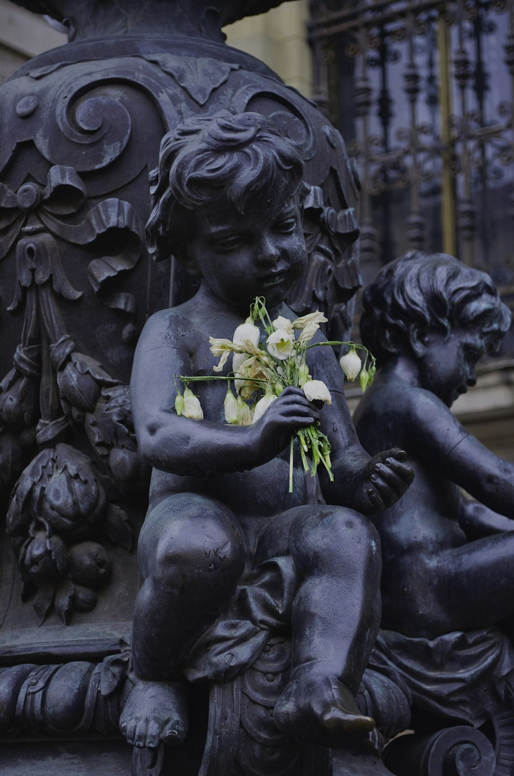 a statue of a child holding a bouquet of flowers