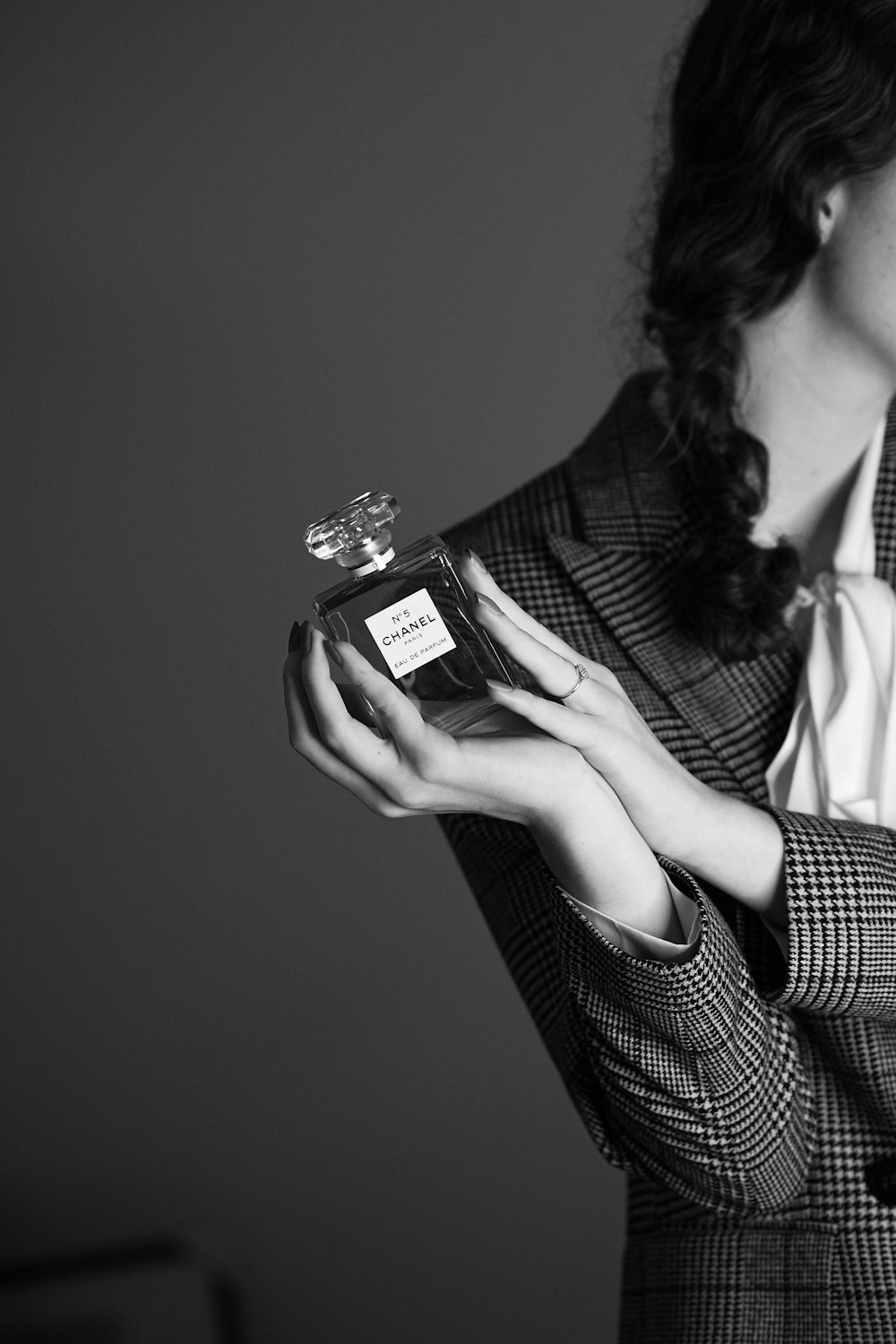 a woman holding a bottle of perfume in her hands