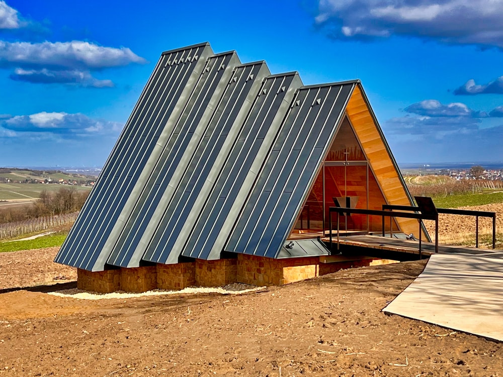 a small building with a metal roof on a dirt field