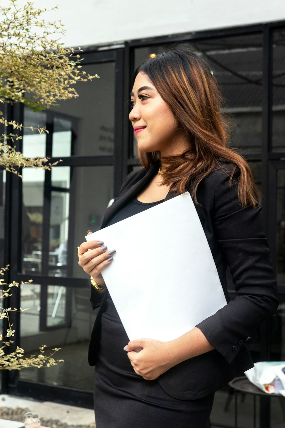 a woman in a black dress holding a white piece of paper