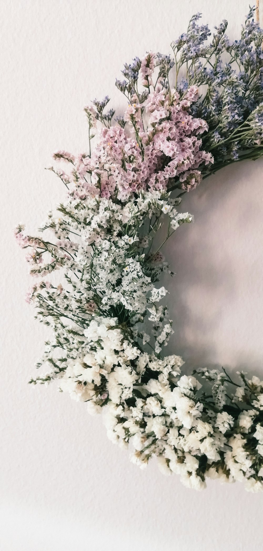 a wreath of dried flowers hanging on a wall