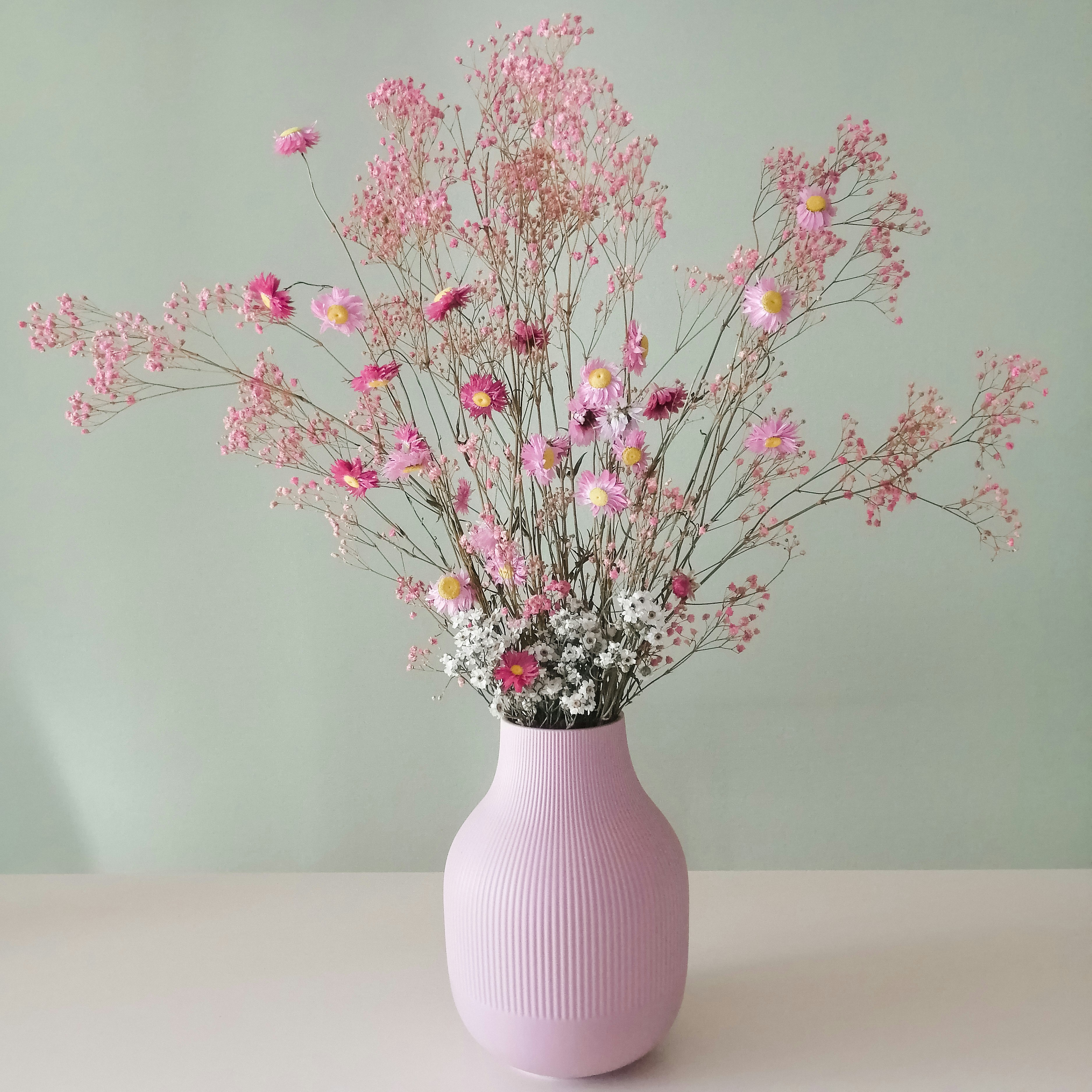 a pink vase filled with lots of pink flowers
