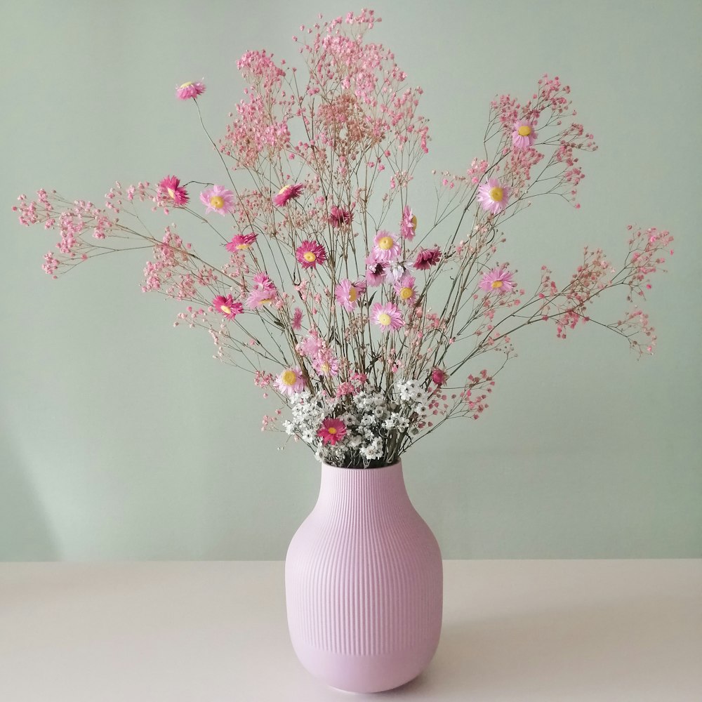 a pink vase filled with lots of pink flowers