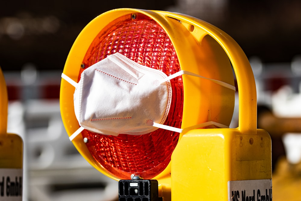 a yellow traffic light with a face mask on it
