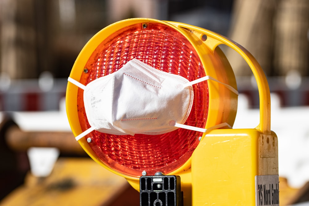 a yellow traffic light with a white mask on it