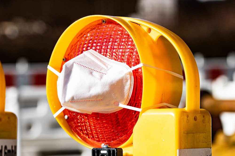 a yellow traffic light with a face mask on it
