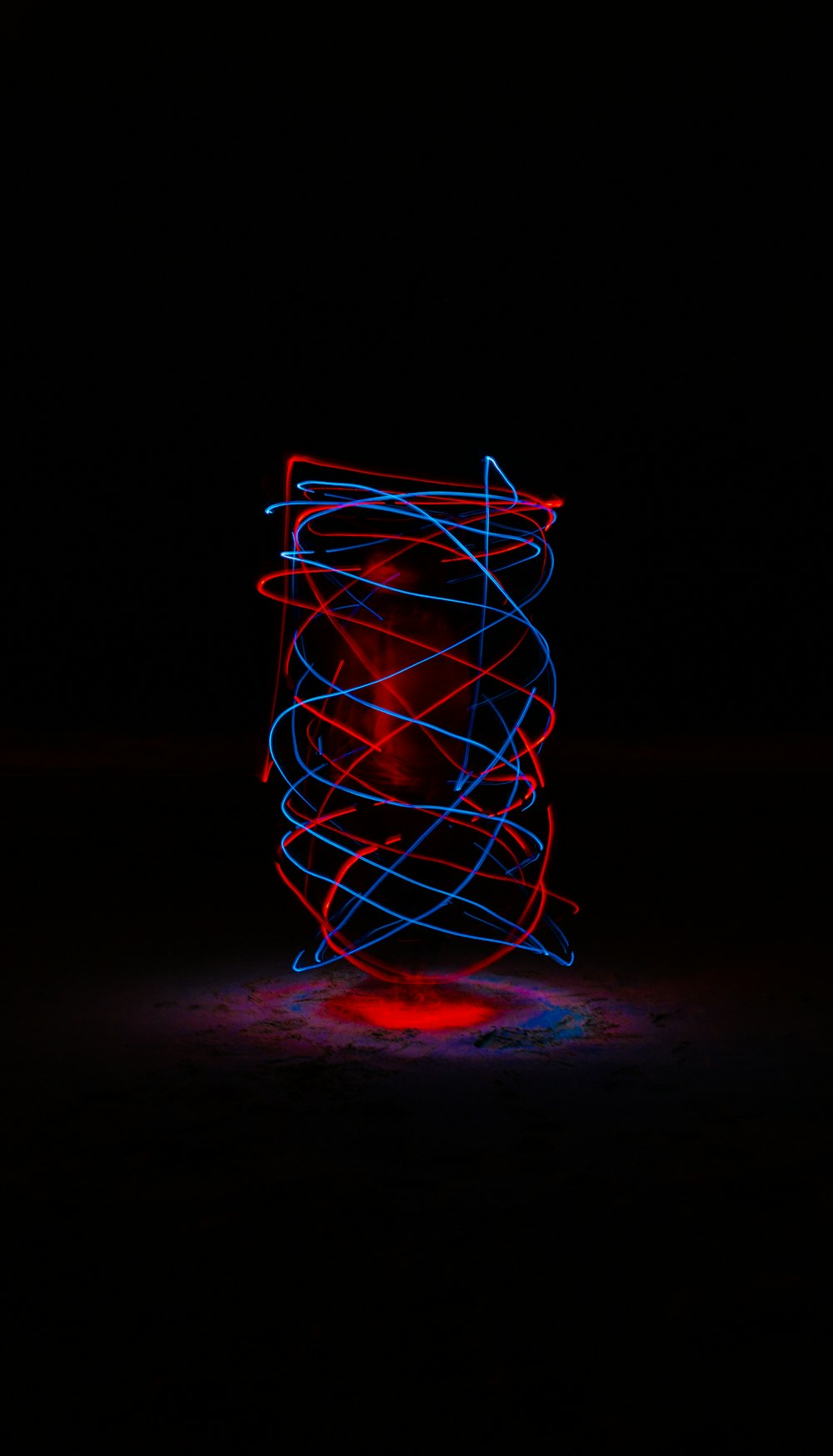 a red, white and blue light painting on a black background