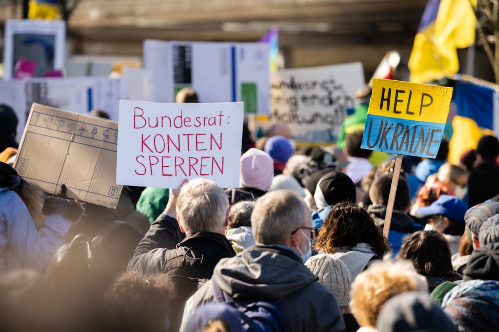 a crowd of people holding signs and placards