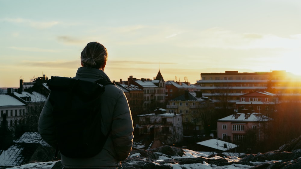 une personne debout au sommet d’une colline enneigée