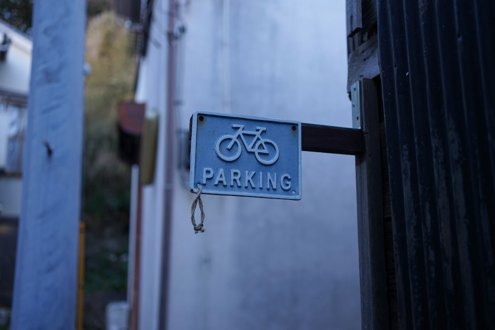 a blue parking sign hanging from the side of a building