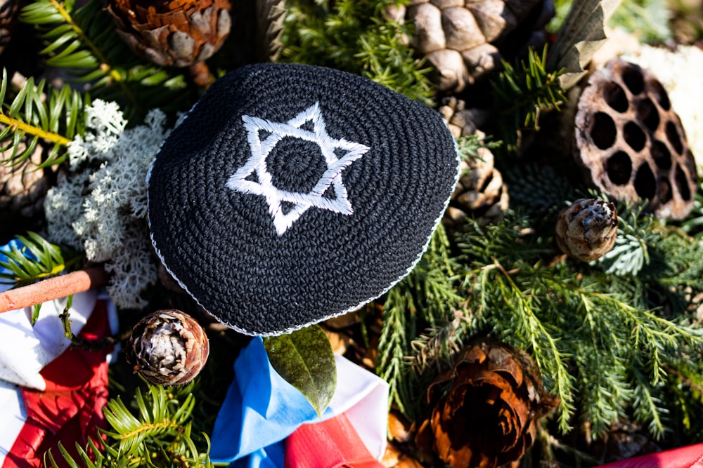 a crocheted hat sitting on top of a pile of pine cones