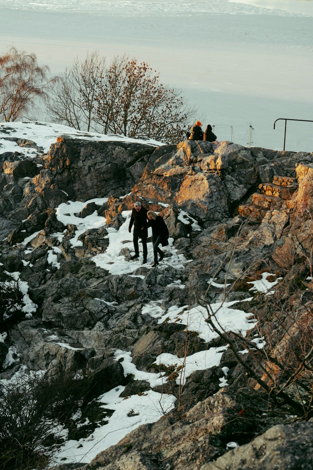 a group of people on a rock in the snow