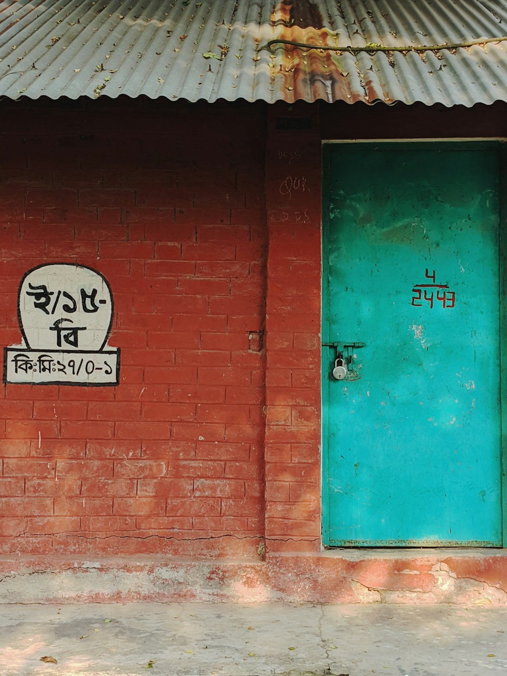 a red brick building with a green door