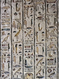 Intricate hieroglyphs etched into a pyramid wall, glowing softly in the light of a torch.