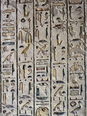 Interior of a dark, mysterious temple wall adorned with subtle symbols blending Guarani and Egyptian mythology.