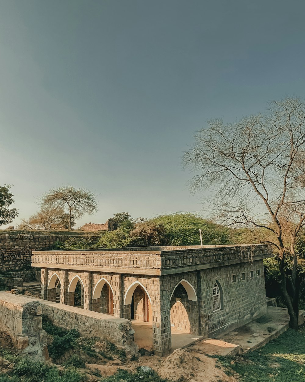 a stone building with a tree in the background