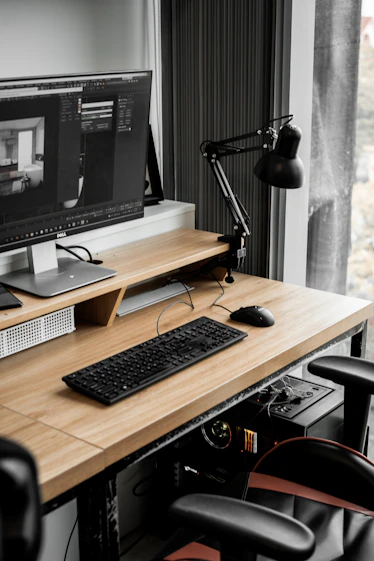 A sleek workstation displaying complex 3D architectural models and parametric design scripts on multiple monitors.