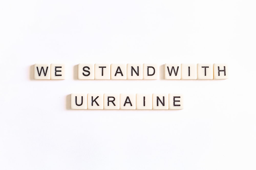 two scrabble tiles spelling we stand with ukraine