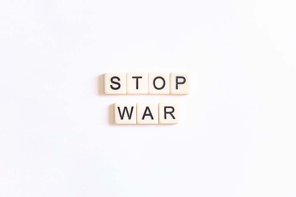 Due tessere di scrabble che scrivono Stop War su uno sfondo bianco