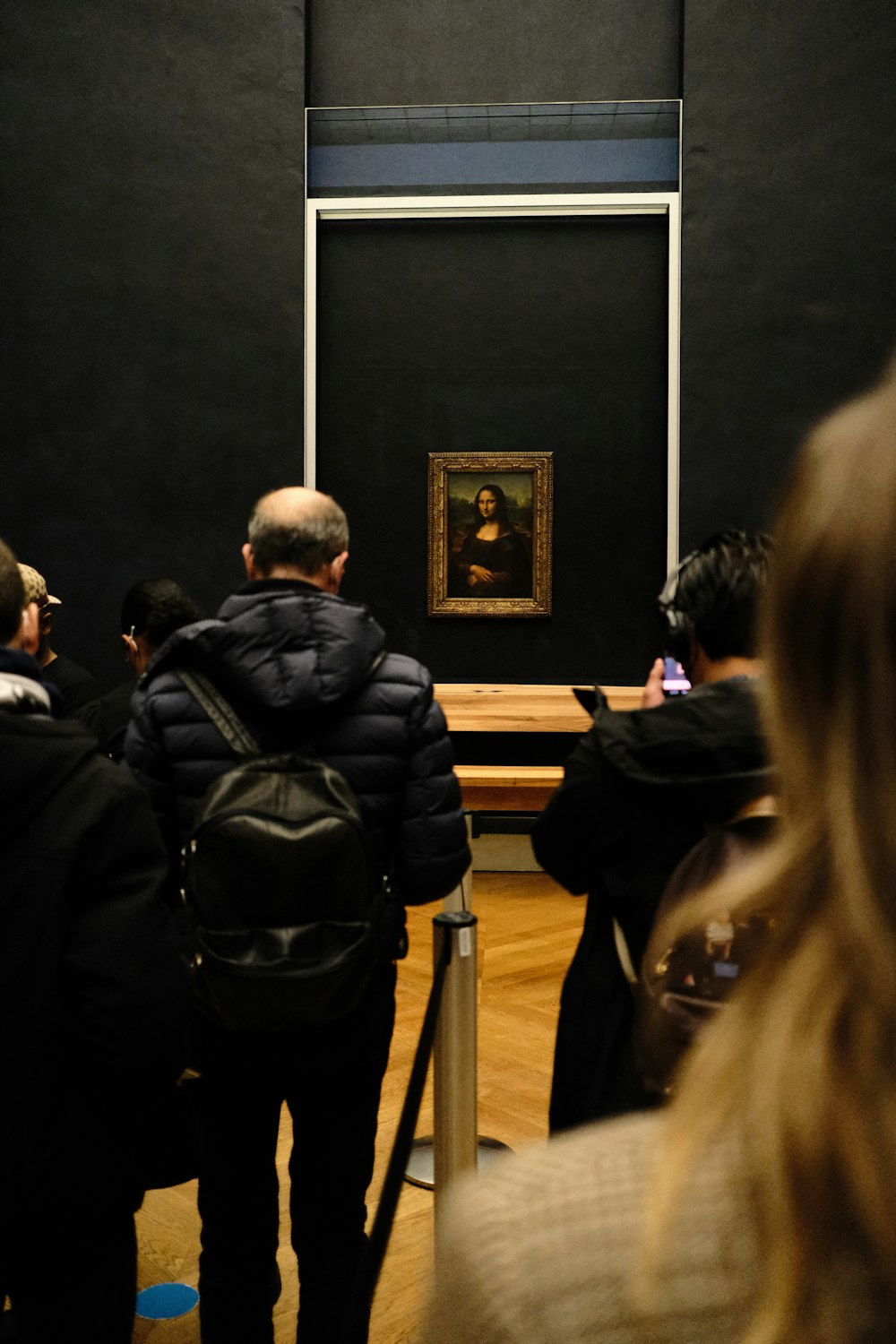 a group of people standing in front of a painting