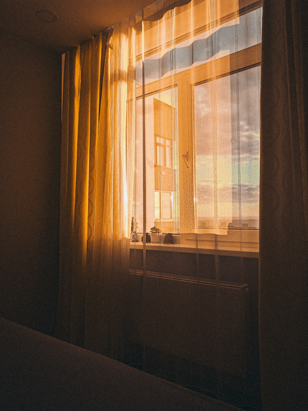 the sun is shining through the curtains of a window