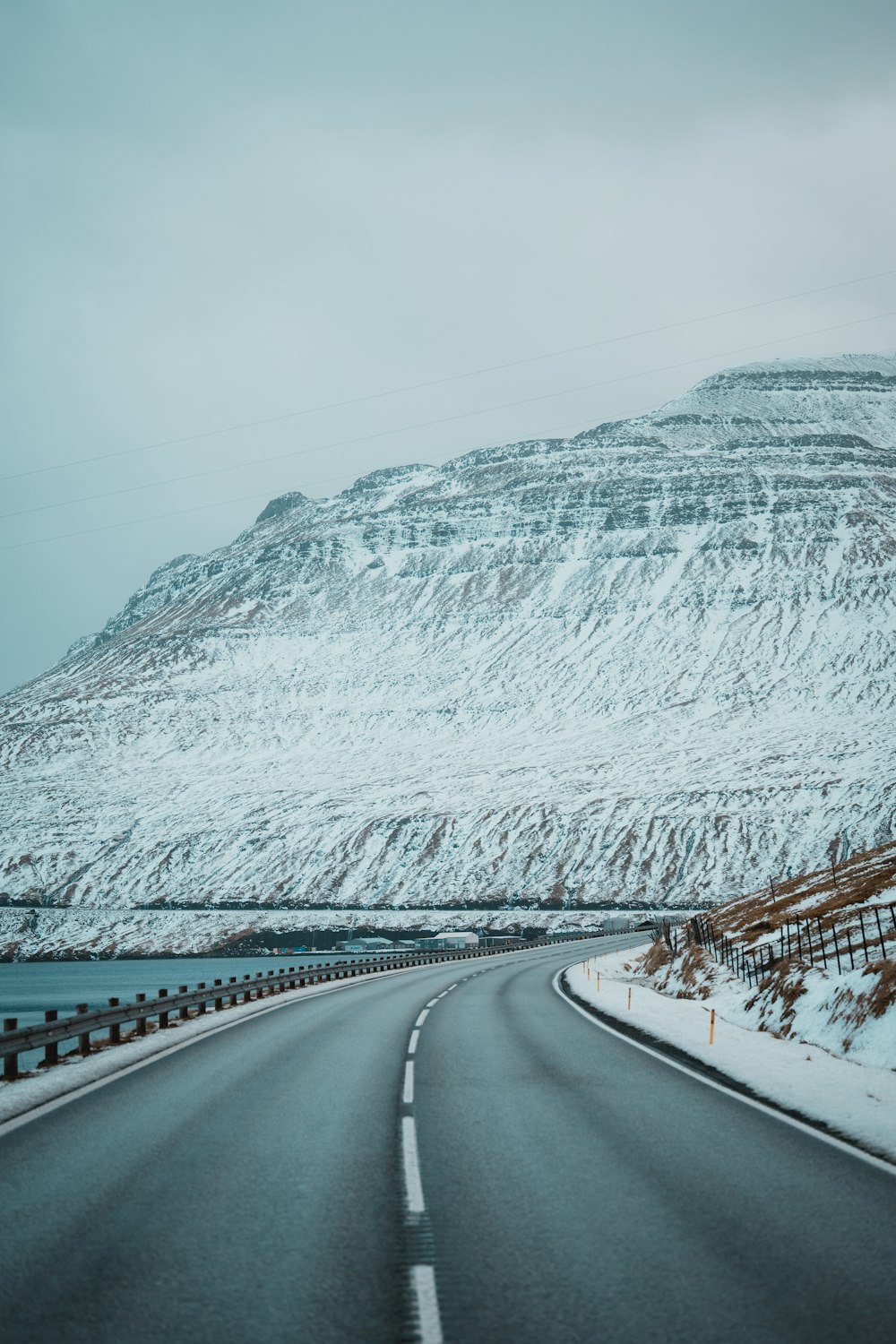 a snowy road with a mountain in the background