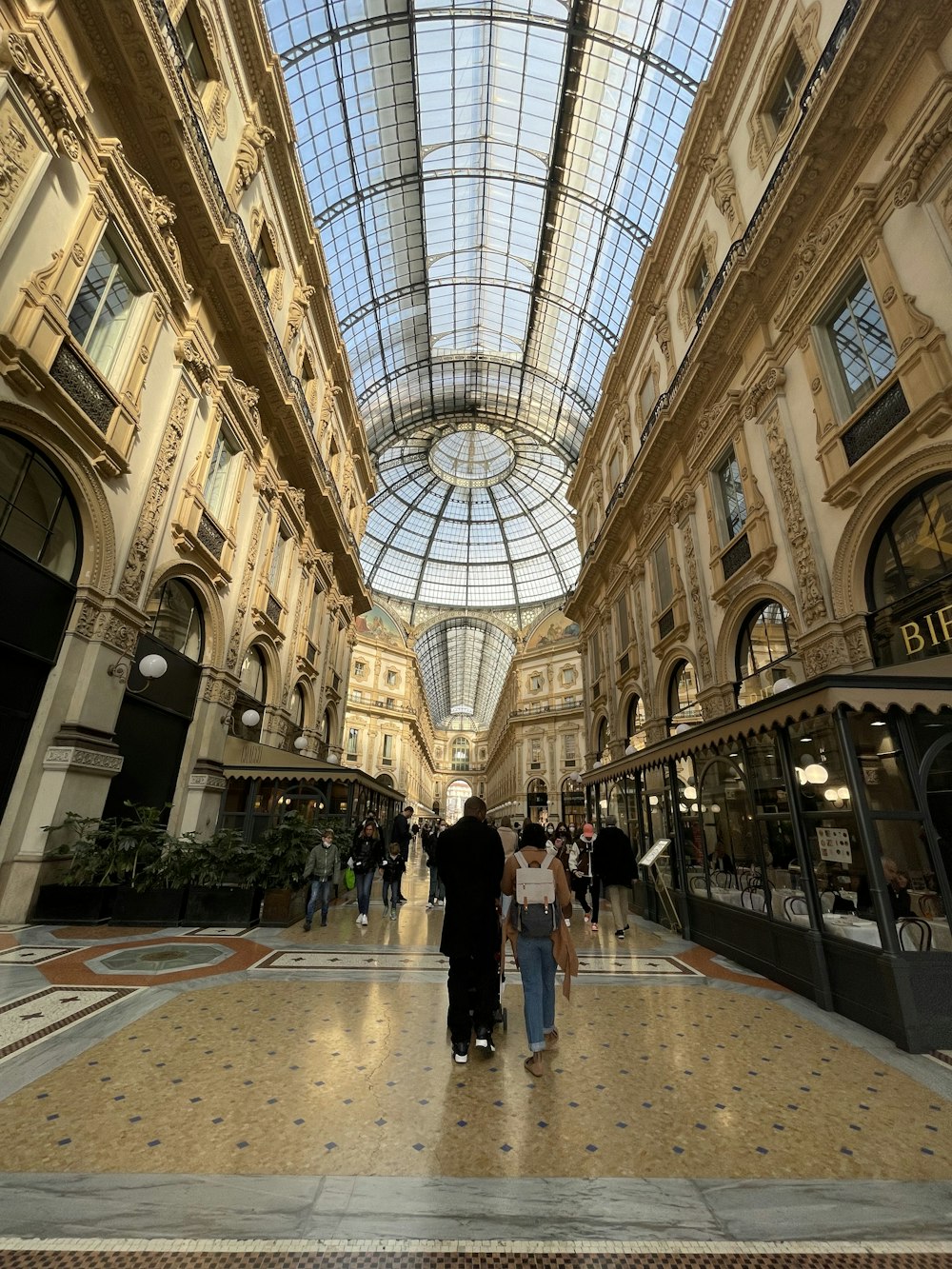 a group of people walking through a shopping mall