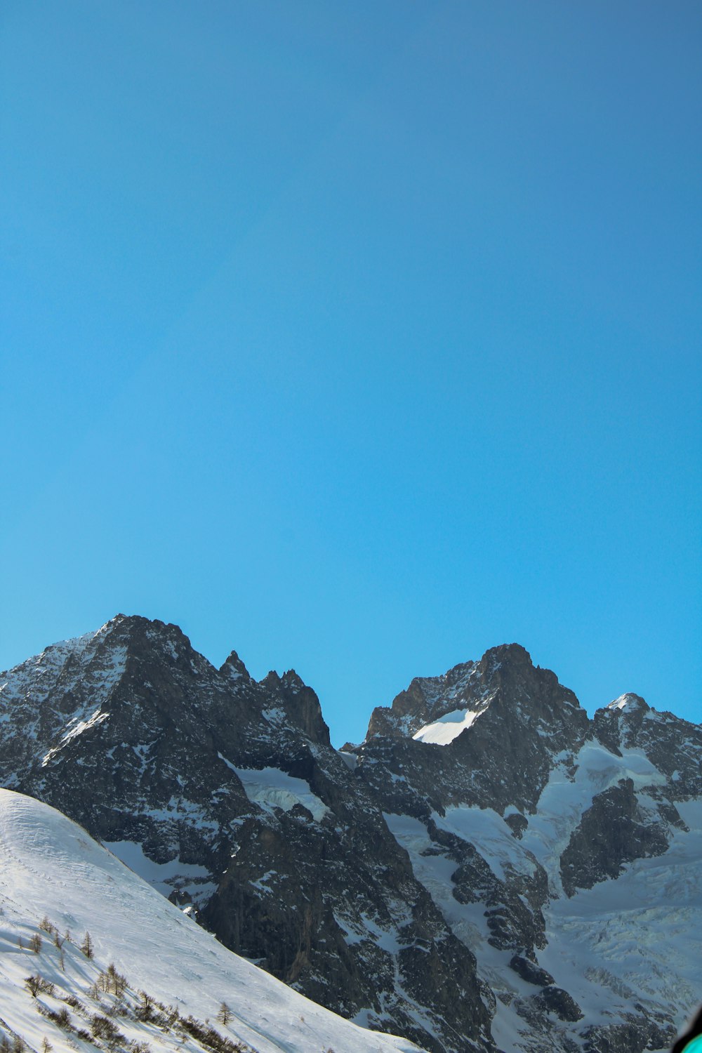 a snowboarder is going down a snowy mountain