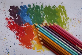 a group of colored pencils sitting next to each other